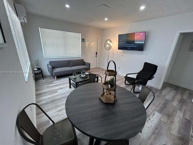 dining space featuring hardwood / wood-style flooring and a wall mounted AC