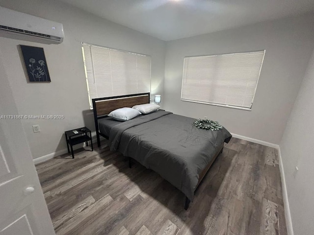 bedroom with wood-type flooring and a wall mounted air conditioner