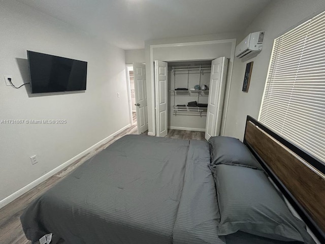 bedroom featuring wood-type flooring, a wall mounted AC, and a closet