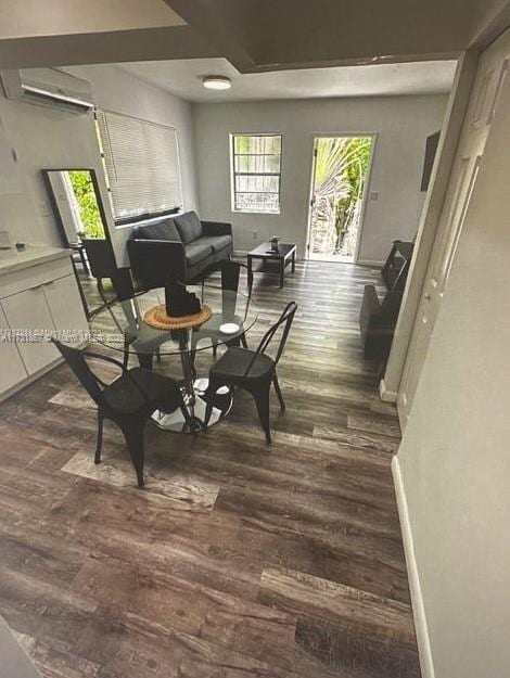 interior space with dark hardwood / wood-style flooring and a wall unit AC