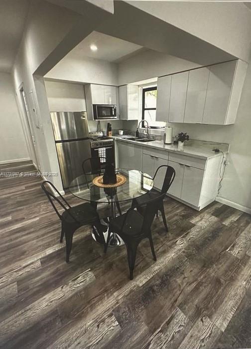 dining area featuring sink and dark hardwood / wood-style flooring