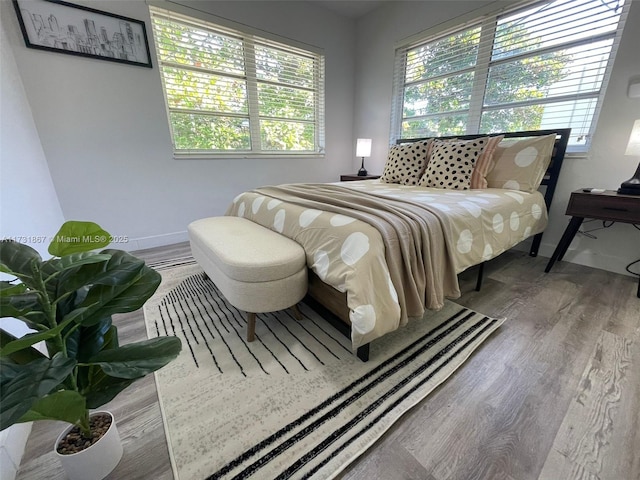 bedroom with wood-type flooring and multiple windows