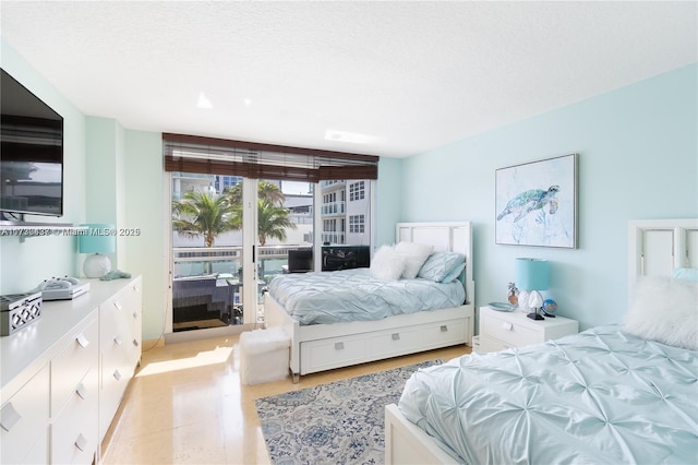 bedroom with access to outside and a textured ceiling