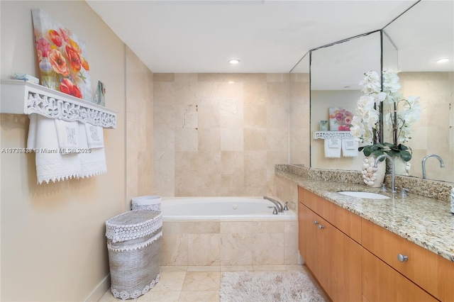 bathroom with tiled tub and vanity