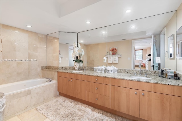 bathroom with vanity and tiled tub