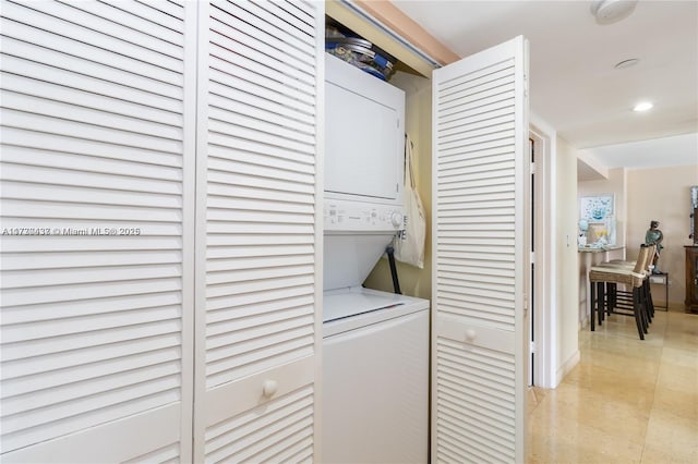 clothes washing area featuring stacked washing maching and dryer