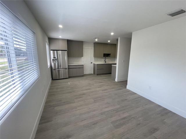 unfurnished living room with sink and light hardwood / wood-style floors