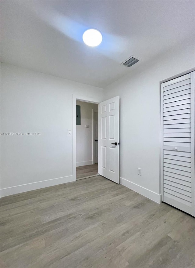 unfurnished bedroom featuring light hardwood / wood-style floors and a closet