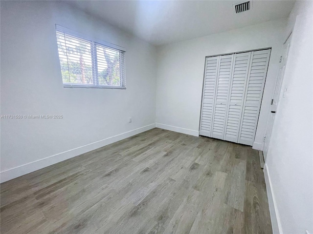 unfurnished bedroom featuring light hardwood / wood-style floors and a closet