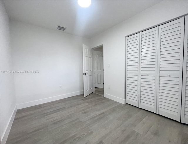 unfurnished bedroom with a closet and light hardwood / wood-style flooring