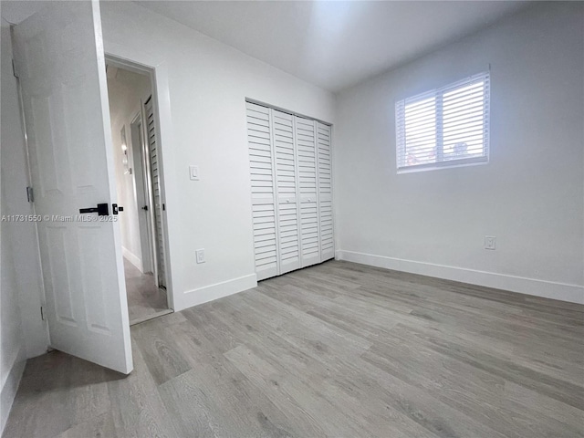 unfurnished bedroom featuring light hardwood / wood-style flooring and a closet