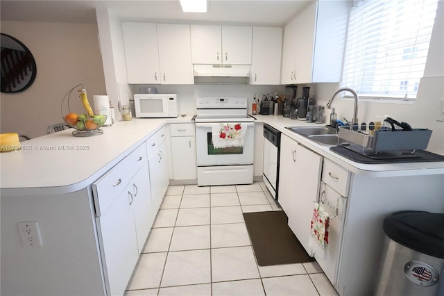 kitchen with white appliances, kitchen peninsula, and white cabinets