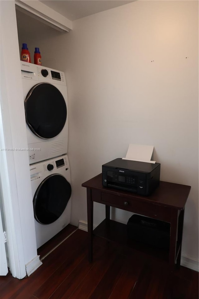 laundry room featuring dark hardwood / wood-style flooring and stacked washer / drying machine