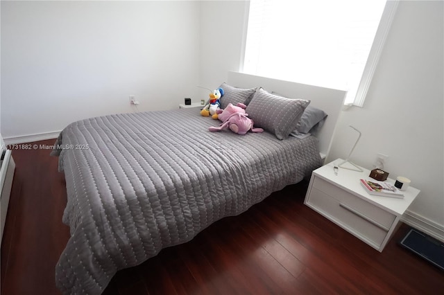 bedroom with dark wood-type flooring