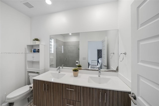 bathroom with vanity, a shower with shower door, and toilet