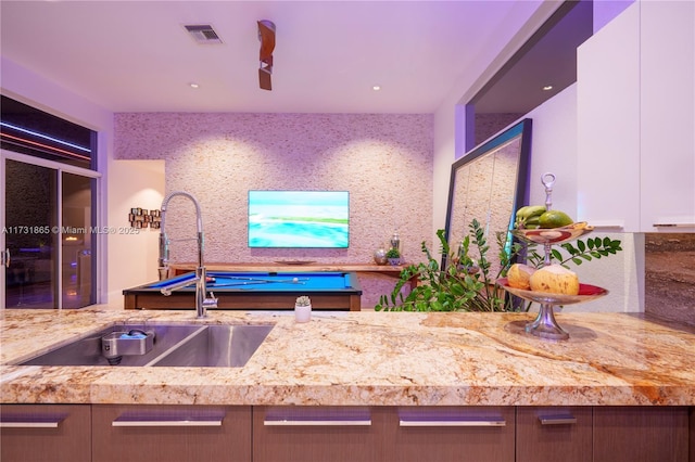 kitchen featuring white cabinetry, tasteful backsplash, sink, and light stone counters