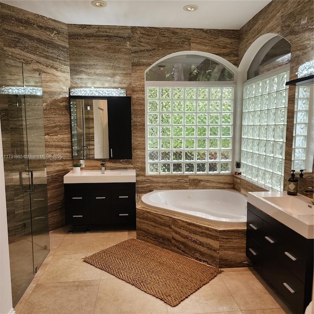 bathroom featuring tile patterned flooring, vanity, tile walls, and plus walk in shower