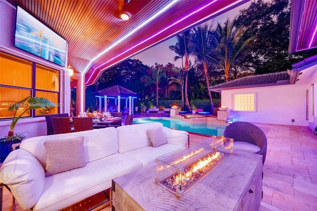 view of patio with an outdoor living space with a fire pit