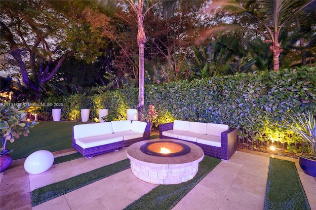 view of patio with an outdoor living space with a fire pit