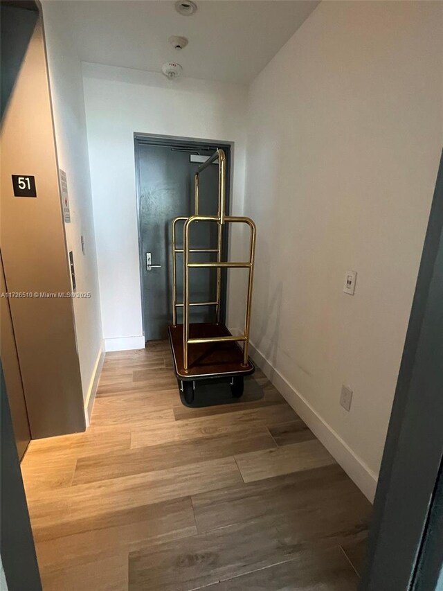 spare room featuring a healthy amount of sunlight, a wall of windows, and light hardwood / wood-style floors