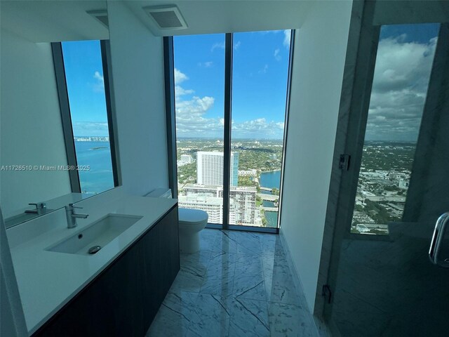 unfurnished room with a water view, floor to ceiling windows, and hardwood / wood-style floors