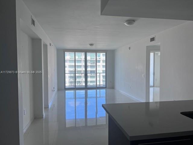 kitchen featuring light tile patterned floors and a wall of windows