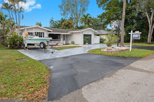 single story home with a garage and a front yard