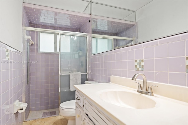 bathroom featuring vanity, toilet, and tile walls