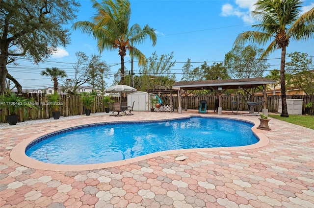 view of pool featuring a gazebo, a storage unit, and a patio area