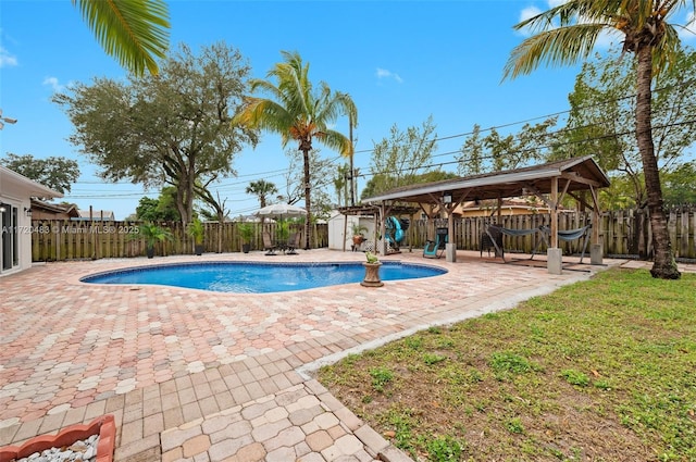 view of swimming pool with a patio, a yard, a gazebo, and a storage unit