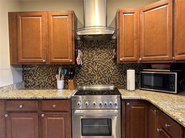 kitchen featuring tasteful backsplash, light stone countertops, exhaust hood, and electric range