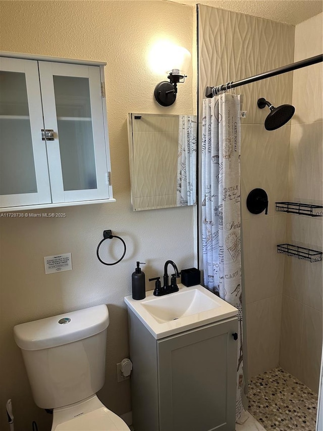 bathroom with vanity, curtained shower, and toilet