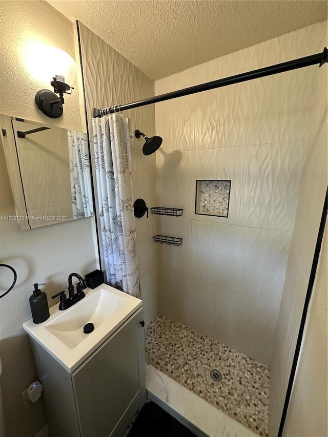 bathroom featuring vanity, a shower with curtain, and a textured ceiling