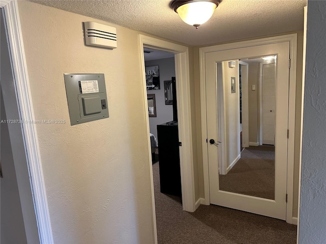 corridor featuring carpet floors and a textured ceiling