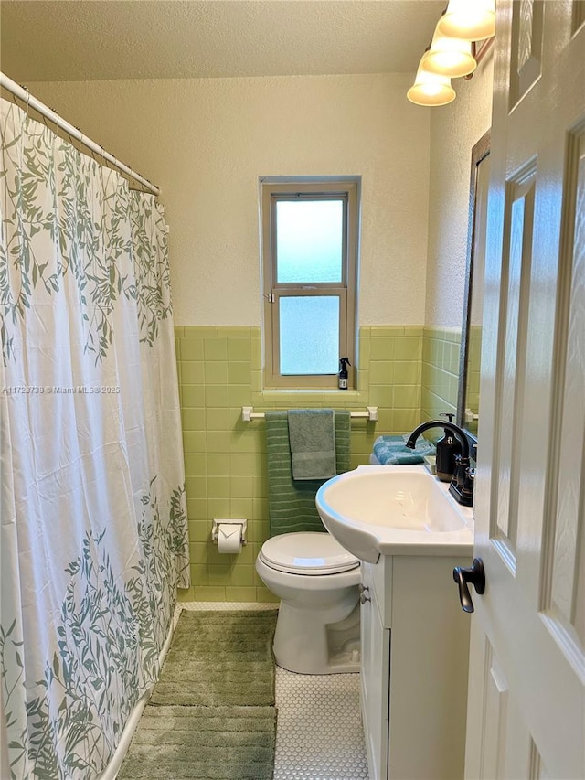 bathroom featuring tile walls, vanity, tile patterned flooring, and toilet