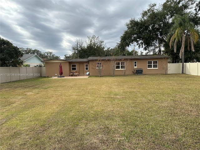 rear view of property with a yard, cooling unit, and a patio area