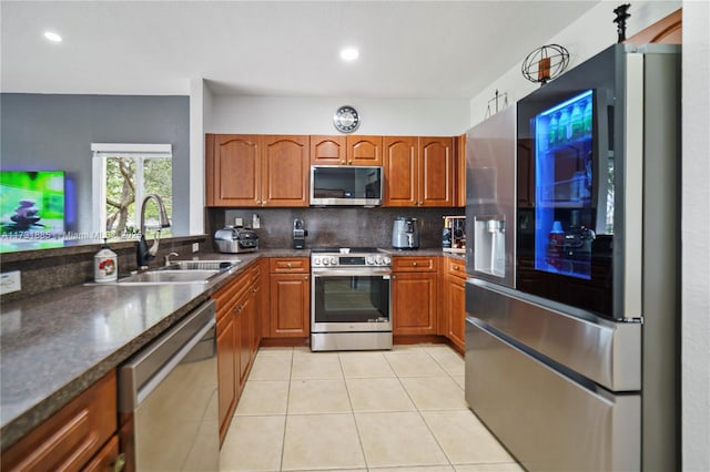 kitchen with tasteful backsplash, stainless steel appliances, sink, and light tile patterned floors