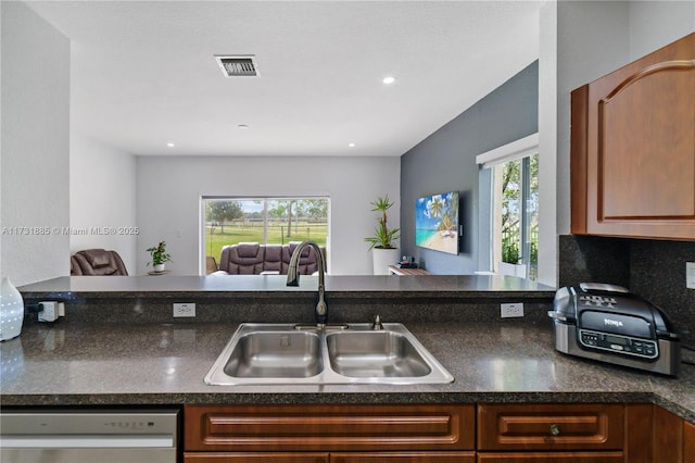 kitchen featuring dishwasher, sink, backsplash, and kitchen peninsula