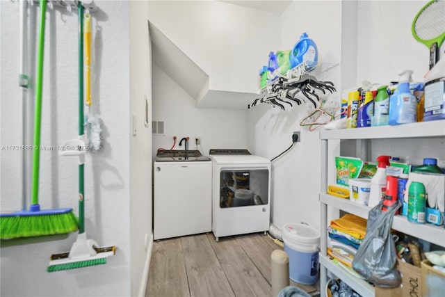 washroom with light wood-type flooring and independent washer and dryer