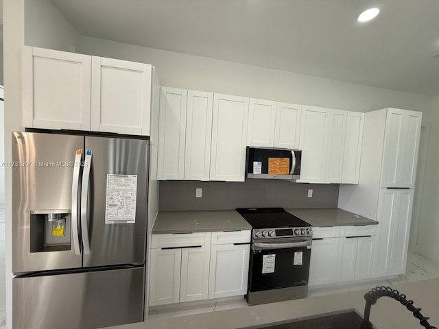 kitchen featuring stainless steel appliances and white cabinets