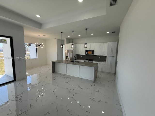 kitchen with sink, a center island with sink, appliances with stainless steel finishes, pendant lighting, and white cabinets