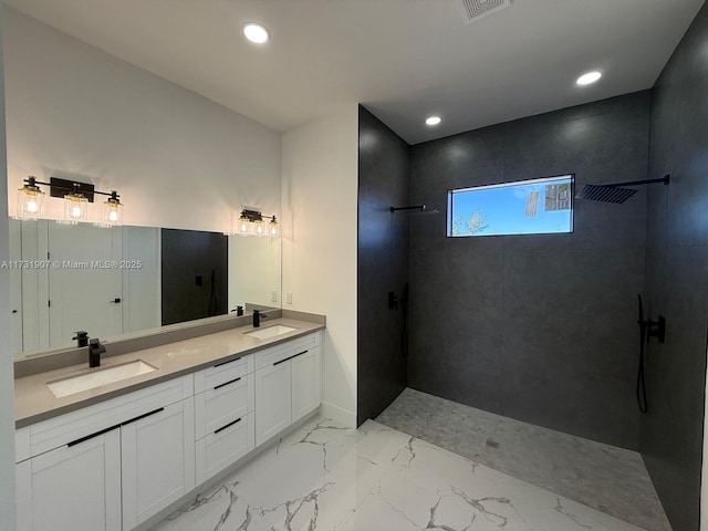 bathroom with vanity and a tile shower