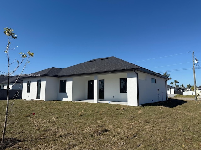 rear view of property with a patio and a yard