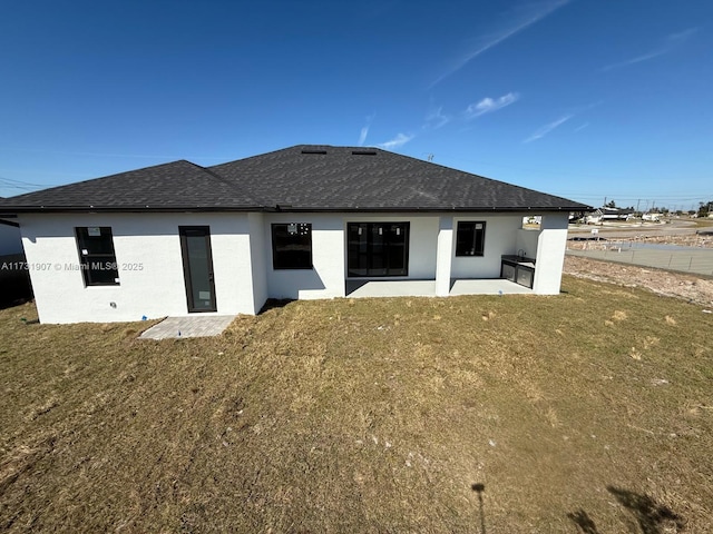 rear view of property with a yard and a patio area