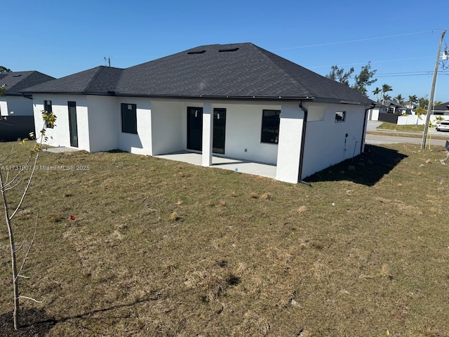 rear view of house featuring a yard and a patio area