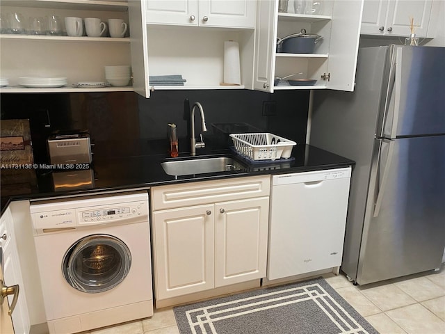 kitchen featuring washer / dryer, sink, light tile patterned floors, stainless steel fridge, and white dishwasher