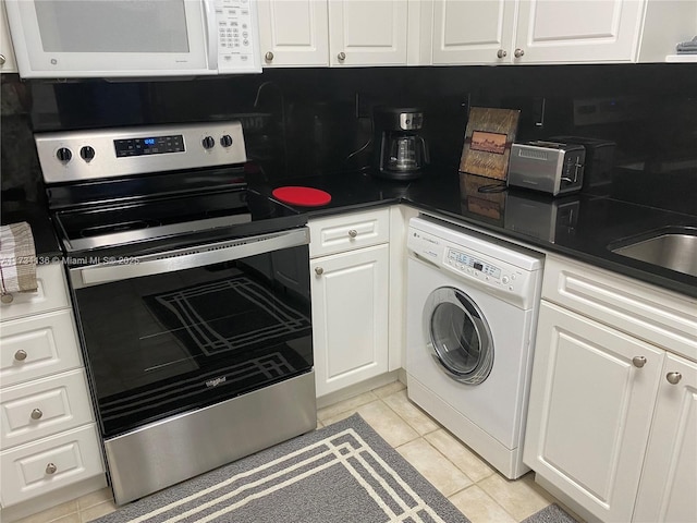 kitchen with white cabinetry, washer / clothes dryer, light tile patterned floors, and electric range