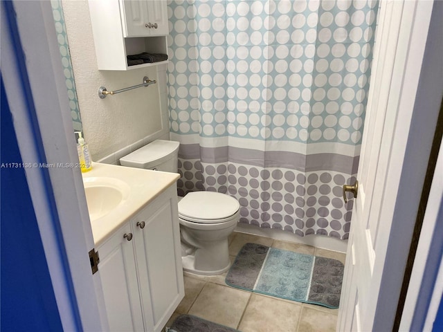 bathroom featuring vanity, tile patterned flooring, and toilet