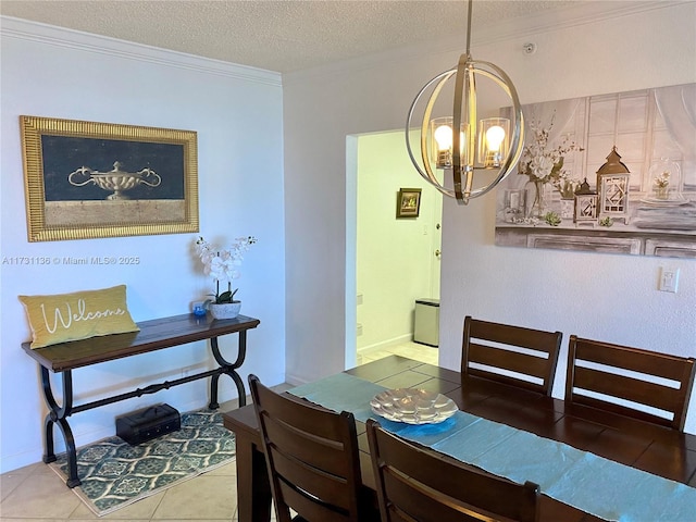 dining area with tile patterned flooring, ornamental molding, a textured ceiling, and an inviting chandelier