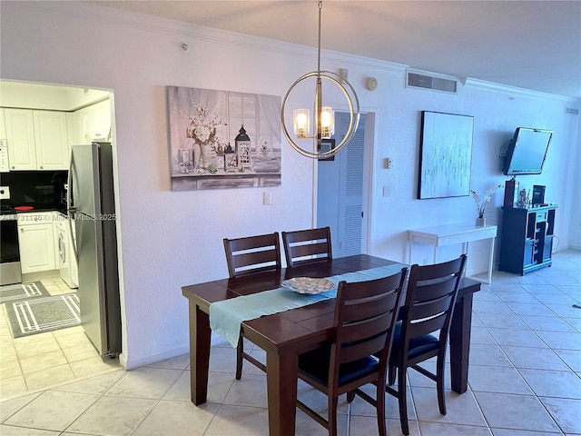 dining area featuring light tile patterned flooring, ornamental molding, and an inviting chandelier